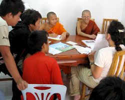 Lao students and novice monks practice English with a visitor in Luang Prabang, Laos.